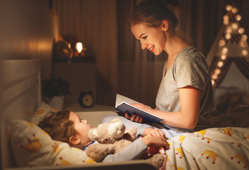 O mamă care îi citește o poveste copilului în timpul rutinei de somn