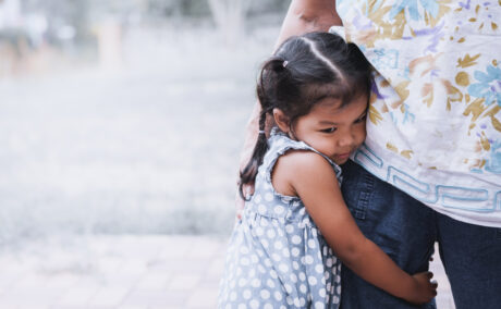 O poză cu o fetiță care îmbrățișează piciorul unui adult, folosită pentru a ilustra un articol despre cum să nu transmiți anxietatea ta copiilor