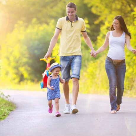 Familie, soț, care ține în mână o bicicletă de copii, colorată soție și copil, care merg pe o alee în parc, ilustrând exercițiile fizice în sarcină