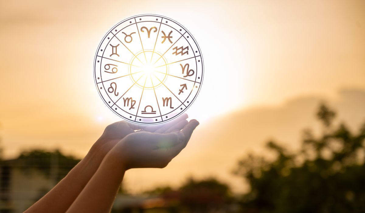 Imagine cu apus de soare în care apar două mâini care țin un cerc al zodiilor, ilustrând horoscopul mamelor