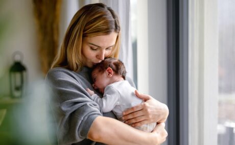 Mamă care își ține nou-născutul în brațe