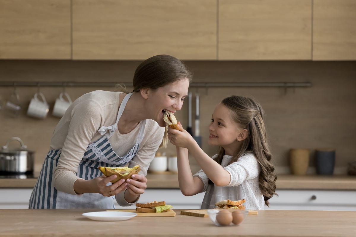Mama si fiica ei se bucură de un mic dejun sănătos în bucătărie