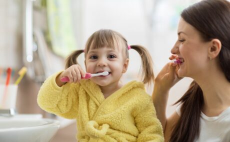 Mamă și fiică se spală pe dinți