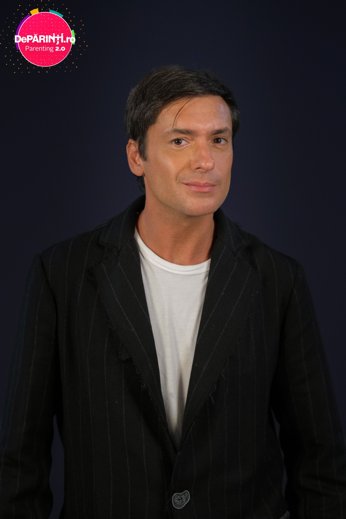 Radu Vâlcan, într-un sacou negru, cu un tricou alb, cu părul într-o parte