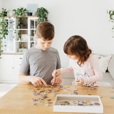 Băiat și fetiță fac împreună un puzzle
