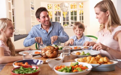 Familie compusă din mamă, tată și doi copii ia cina acasă