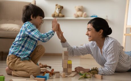 Mama și băiatul construiesc împreună din cuburi de lemn