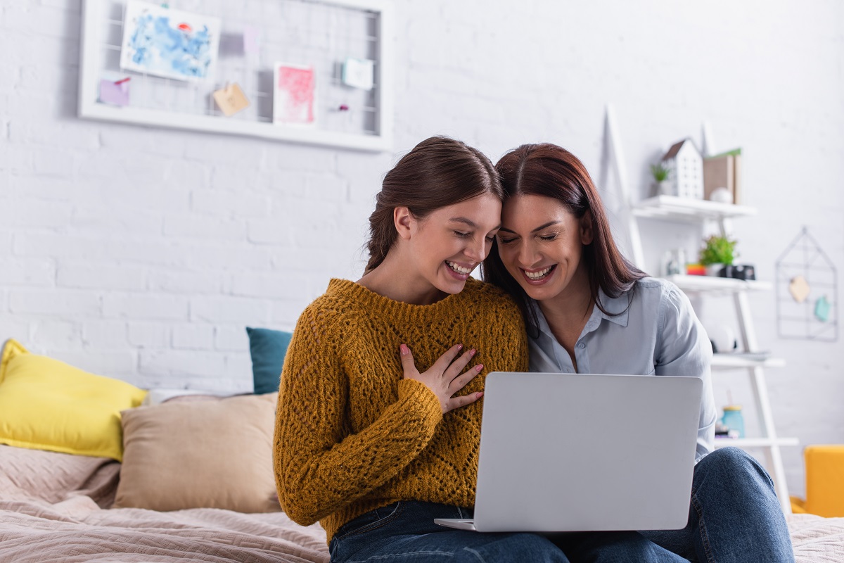 Mama și fata ei adolescentă se uită pe laptop