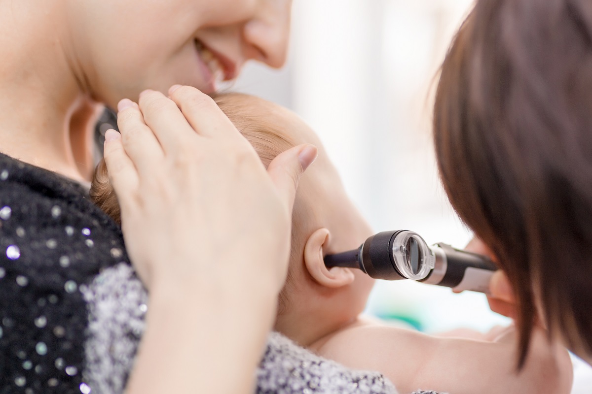 Medicul consultă bebelușul în urechi