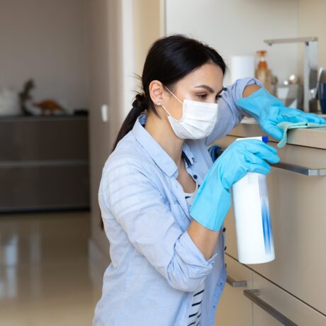 Femeie care dezinfectează blatul din bucătărie
