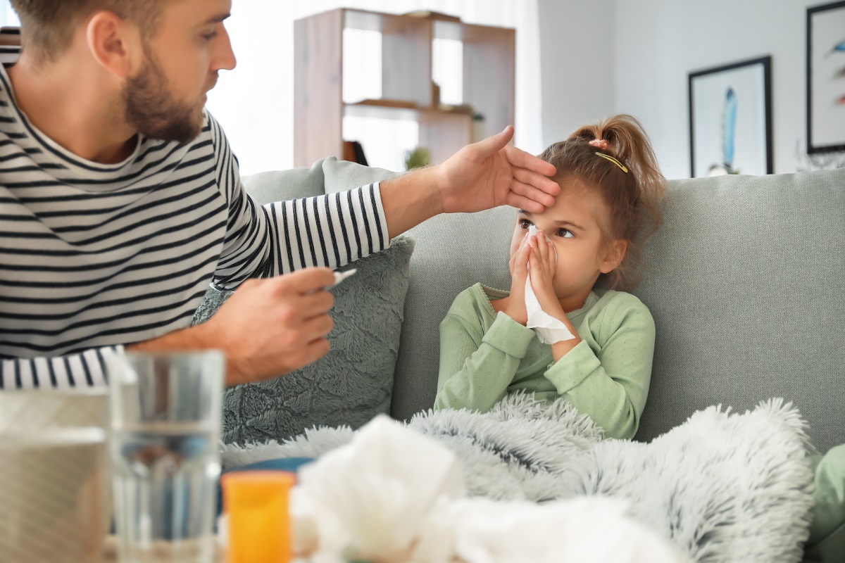 Tatăl îi verifică fetiței care este bolnavă temperatura/Shutterstock