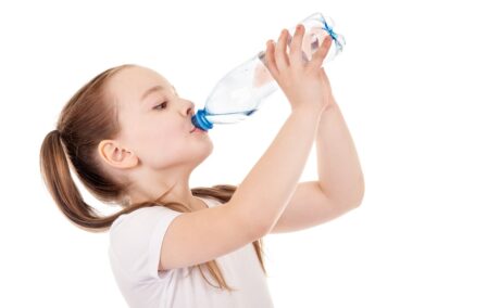 Fetiță bea apă din sticlă