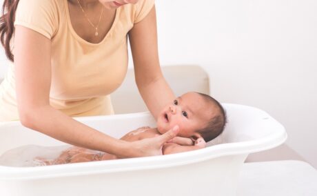 Mama îi face baie nou-născutului