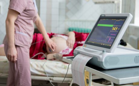 Femeie însărcinată pe patul de spital, la un consult ginecologic