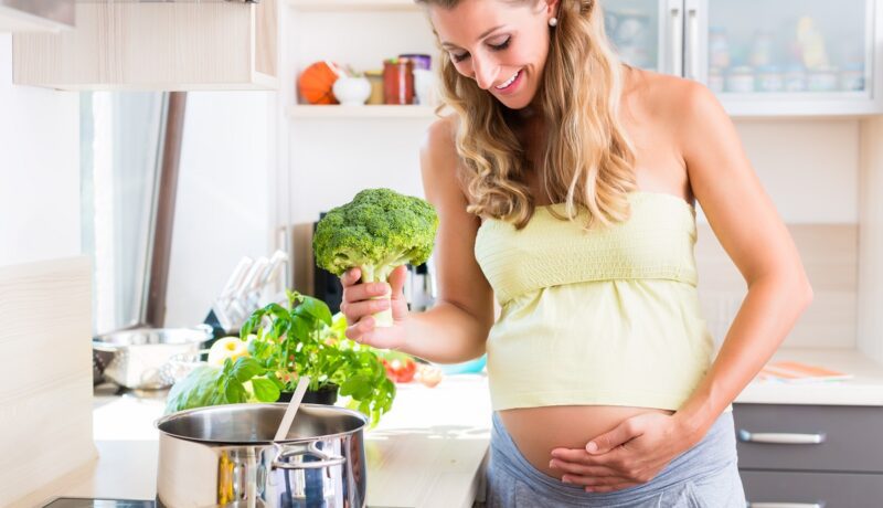 Gravidă își pregătește o mâncare de broccoli