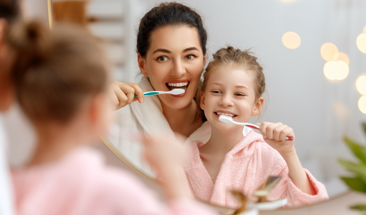 Mama și fiica se spală pe dinți