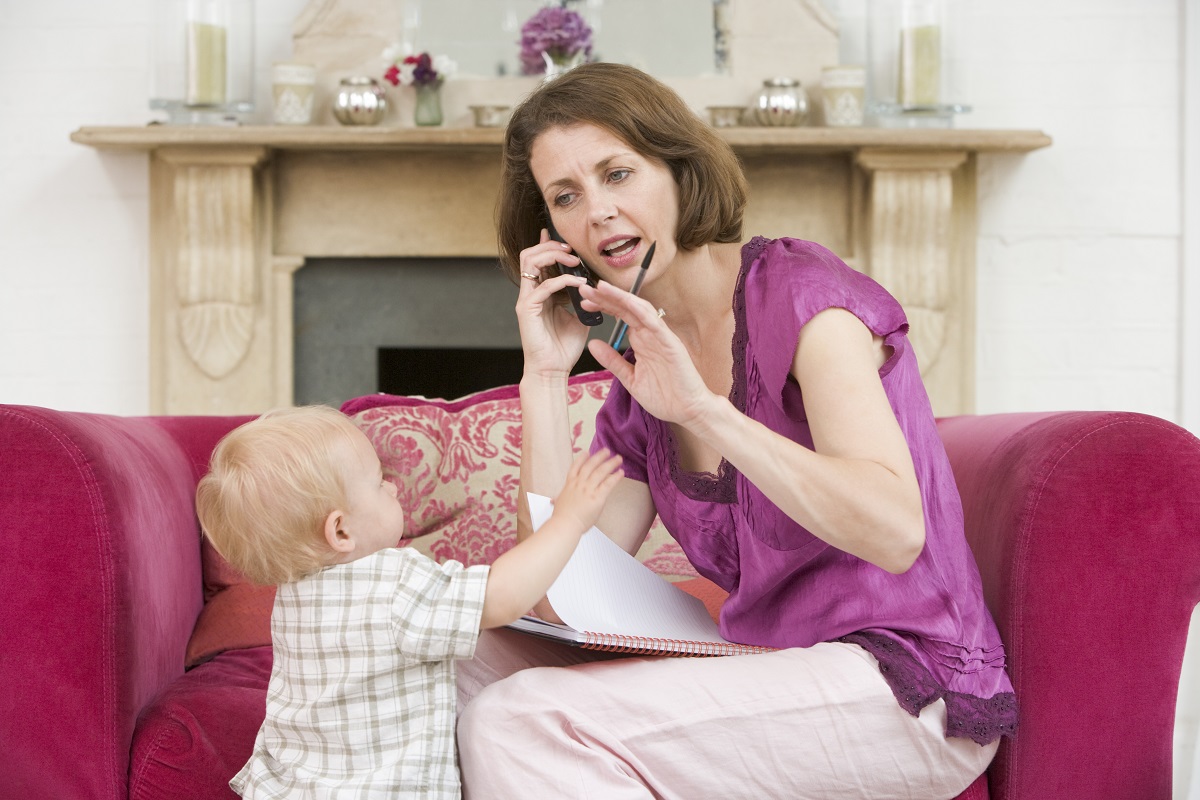 Mama vorbește la telefon, în timp ce bebelușul ar vrea să se joace cu ea