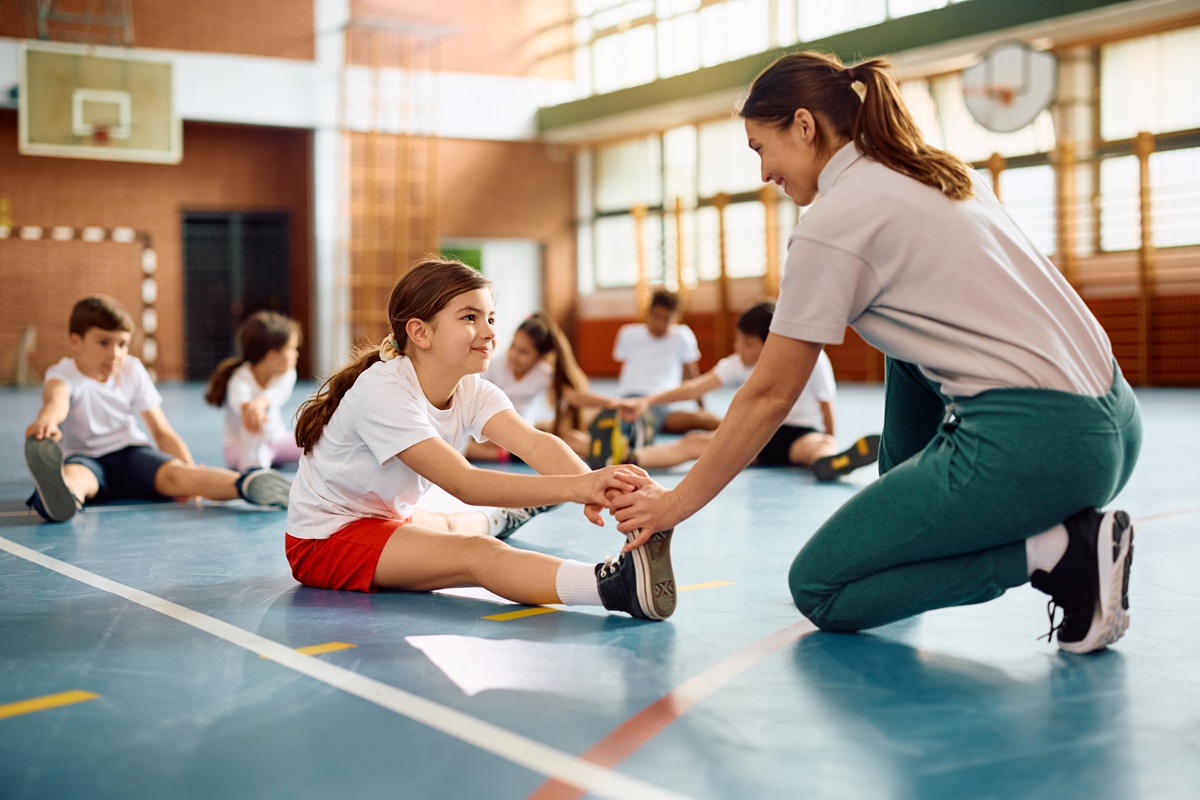 O fetiță care se pregătește cu antrenoarea sa într-o sală de sport