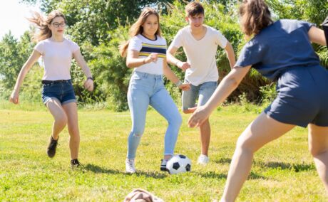 Grup de adolescenți se joacă fotbal