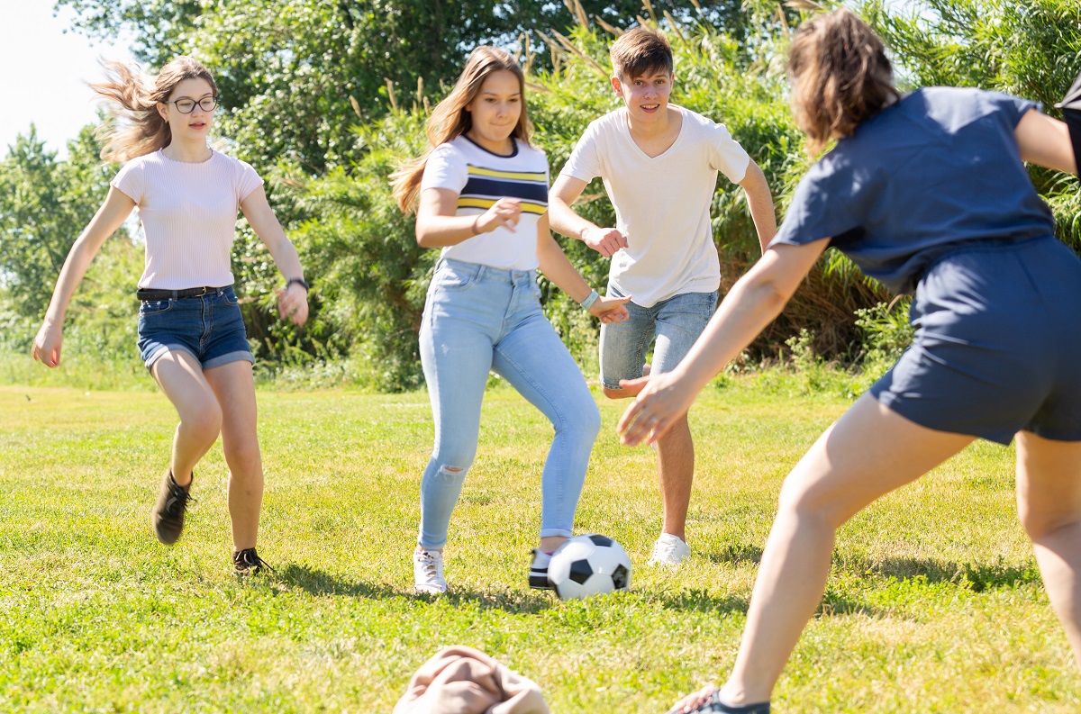 Grup de adolescenți se joacă fotbal