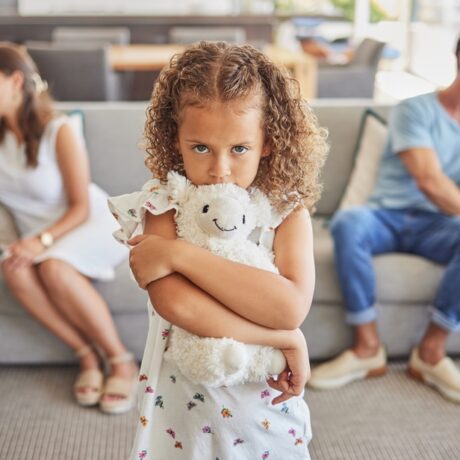 Fată tristă între doi părinți certați care stau pe canapea