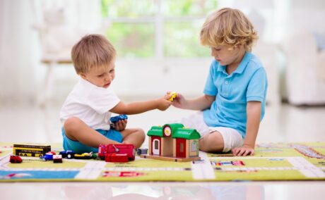 Doi băieți se joacă împreună și împart jucăriile