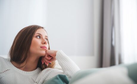 Femeie stă pe canapea gânditoare