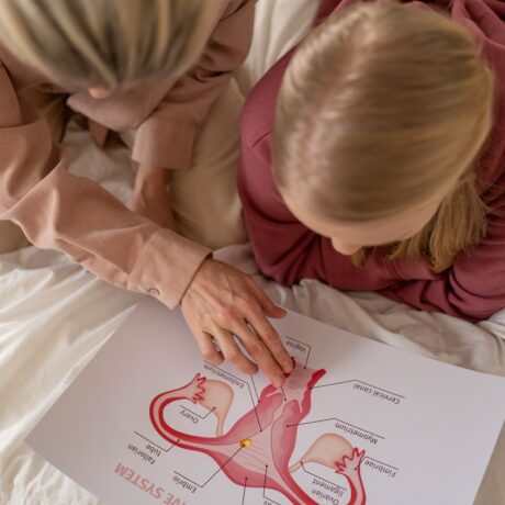 Mama și fiica se uită într-un atlas de anatomie