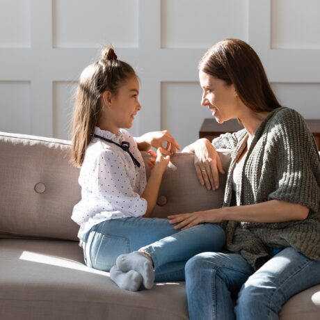 Mama stă de vorbă pe canapea cu fiica ei