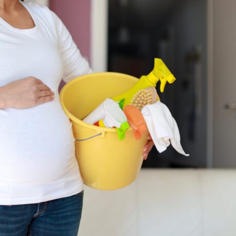 O femeie însărcinată care vrea să curețe casa