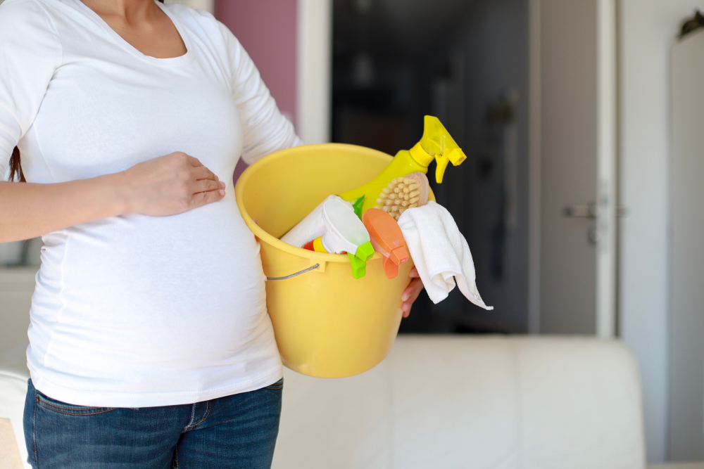 O femeie însărcinată care vrea să curețe casa