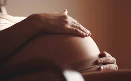 O femeie însărcinată cu mâna pe burtă