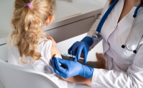 O fetiță care stă la vaccin