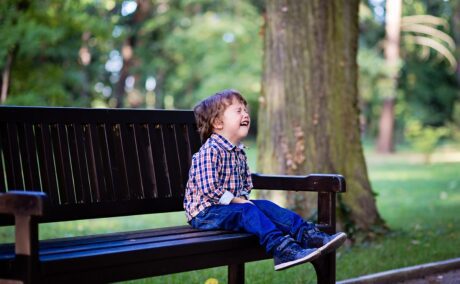 Băiețel stă pe bancă și plânge