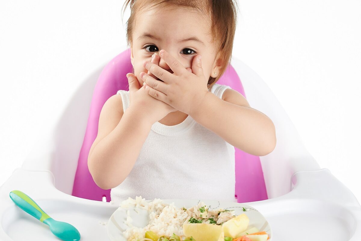 Copilul stă cu mâinile la gură pentru a nu mânca
