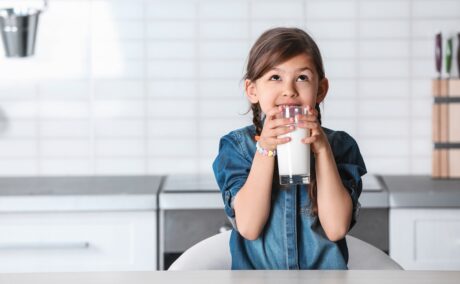 Fetița bea un pahar cu lapte