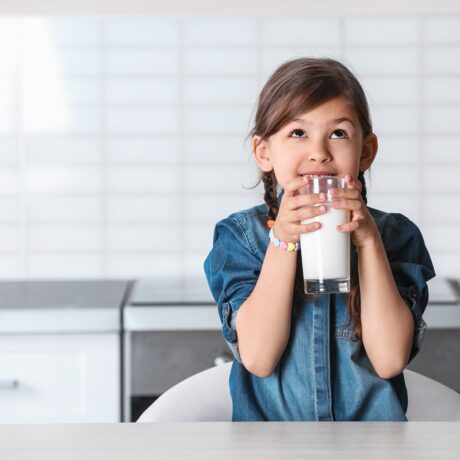 Fetița bea un pahar cu lapte