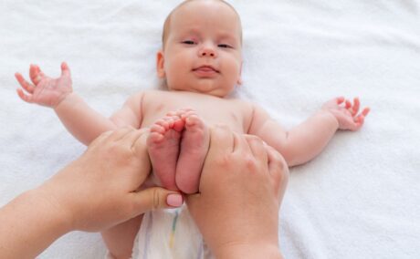 Mama face exerciții pentru burtică cu piciorușele bebelușului