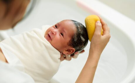 Mama spală bebelușul pe cap