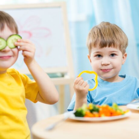 Doui băieței care stau la masă și mânâncă superalimente recomandate pentru dieta unui copil