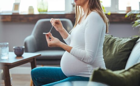 Femeie însărcinată care face un test într-o cameră însorită