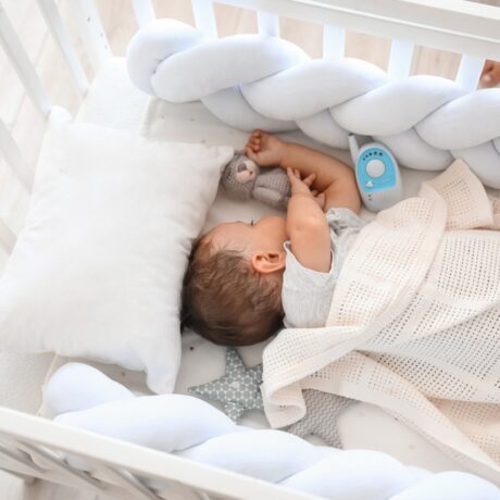 Un bebeluș care doarme în pătuț, cu jucăria preferată