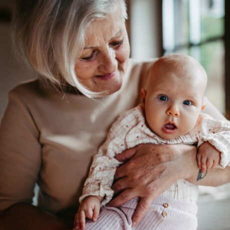 O bunică cu nepoțelul bebeluș în brațe