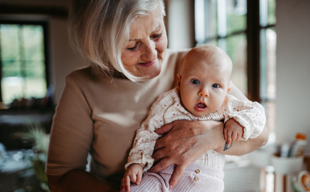 O bunică cu nepoțelul bebeluș în brațe