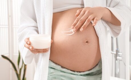 Gravidă se dă cu cremă pe burtă