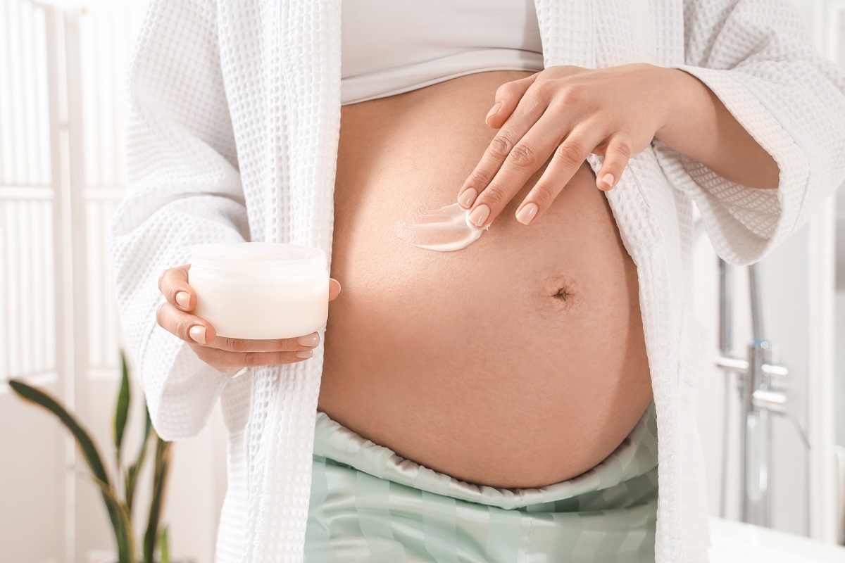 Gravidă se dă cu cremă pe burtă