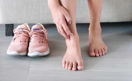 picioare de femeie care stau pe jos pe un fundal deschis la culoare