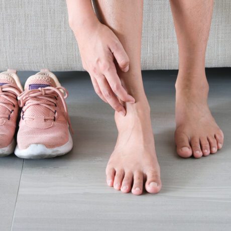 picioare de femeie care stau pe jos pe un fundal deschis la culoare