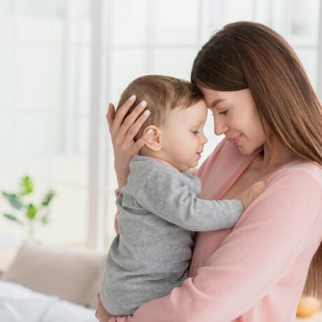 Mama își ține copilul strâns în brațe