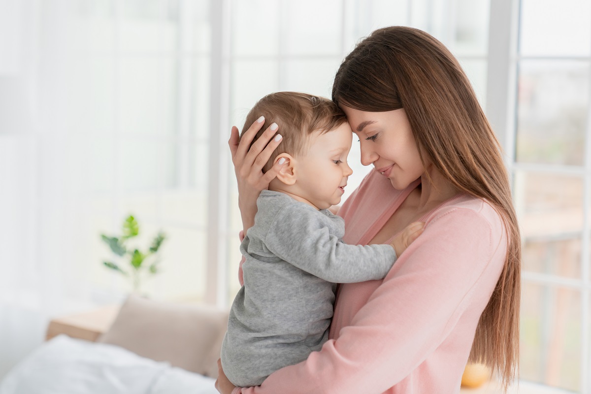 Mama își ține copilul strâns în brațe